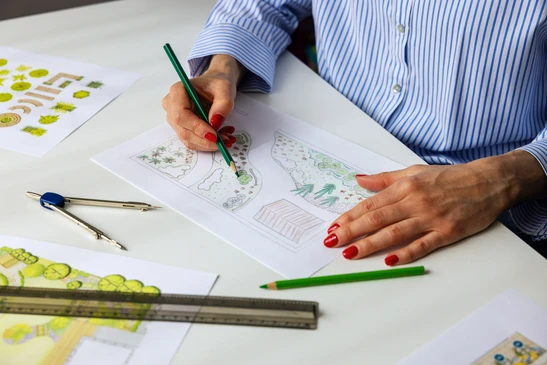 Plan d'aménagement paysager coloré sur table de travail avec instruments de dessin technique