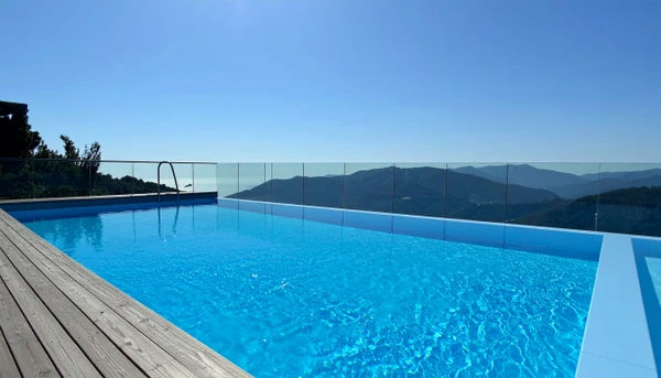 Piscine extérieure luxueuse avec cascade décorative intégrée dans un mur en pierre naturelle